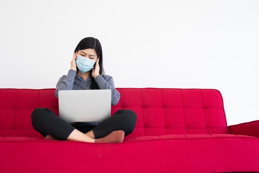 Tired woman wearing a face mask, Headaches and migraines, the suffering of office syndrome after long hours work on the computer. Office syndrome and Health care concept. photo