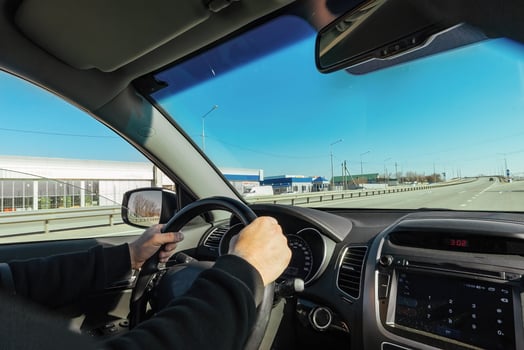 Male driver driving a car on a desert highway photo