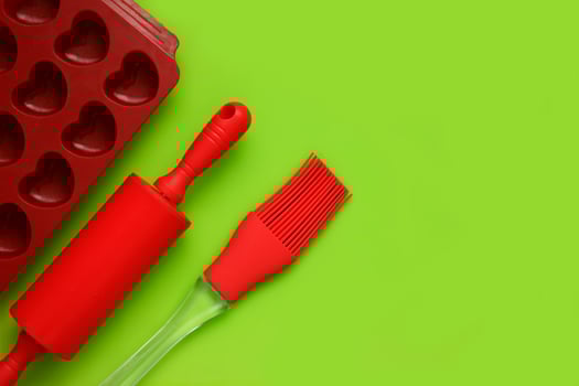 culinary background, culinary spatula, brush, baking dish on a bright green background with copy space photo