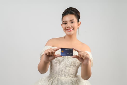 Young asian beautiful bride posting with credit card in hand photo