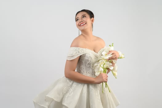 Young asian beautiful bride with orchid bouquet on white background photo
