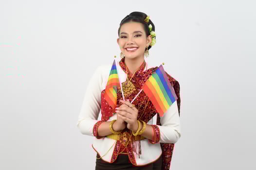 Portrait of Young woman in Thai Northeastern Traditional Clothing holding rainbow flag photo