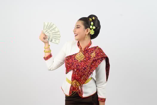 Young beautiful woman in northeastern dress holding fan banknote posting photo