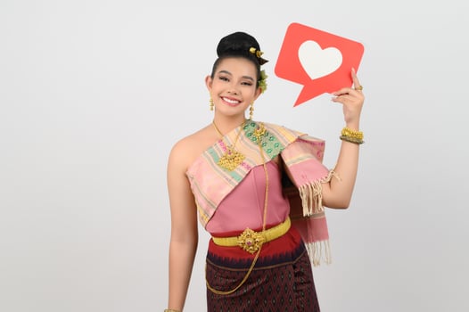 Young beautiful woman in Thai northeastern costume with card in heart symbol photo