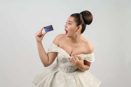 Young asian beautiful bride posting with credit card in hand photo