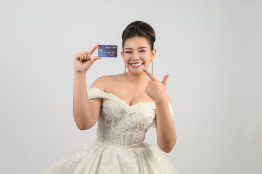 Young asian beautiful bride posting with credit card in hand photo