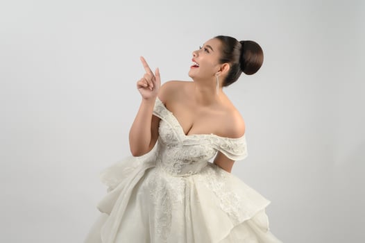 Young asian beautiful bride point finger with happy on white background photo
