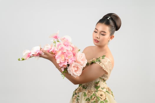 Young asian beautiful bride with orchid bouquet on white background photo