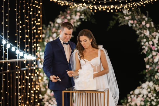 newlyweds happily cut and taste the wedding cake photo