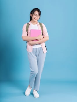 Young Asian student on blue background photo