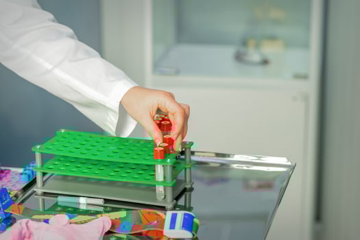 Technician puts test tube to rack photo