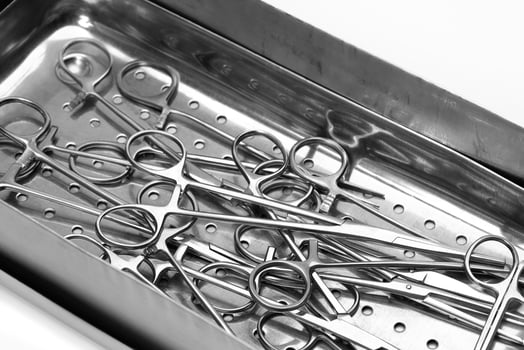 Lot of stainless surgical needle drivers lying on steel tray for sterilize, pack medical instrument photo
