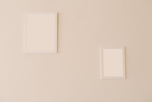 White mockup frames on a beige wall of different sizes photo