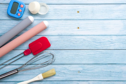 Top view set of kitchen utensils and ingredients for bakery on blue wooden floor. Materials or kitchen equipment for bakery. photo