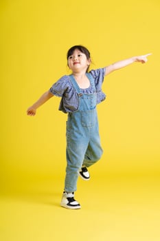 full body image of beautiful asian baby girl on yellow background photo