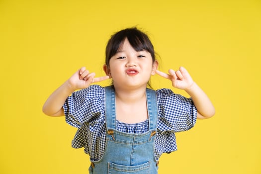 portrait of a beautiful asian girl, isolated on yellow background photo