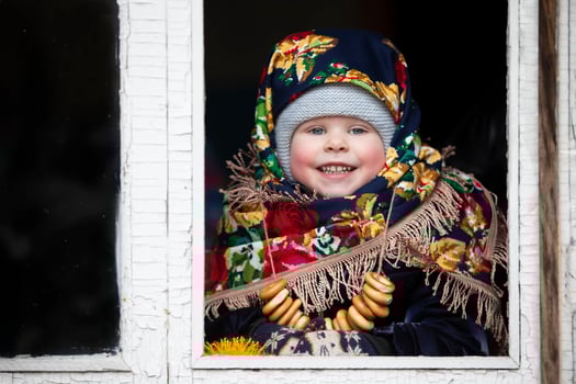 A little girl in a Russian headscarf with bagels at the Maslenitsa holiday. photo