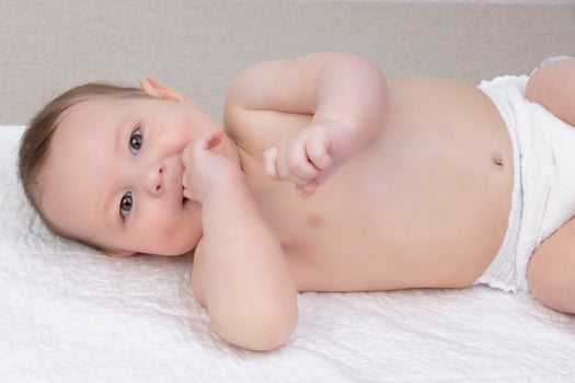 A six-month-old baby boy in a diaper lies on a diaper. The concept of motherhood and fatherhood. photo