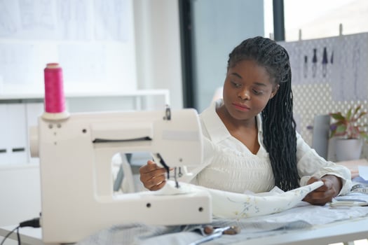 A woman is working on a sewing machine photo