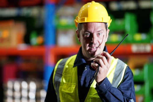 A man in a hard hat holding a walkie talkie photo