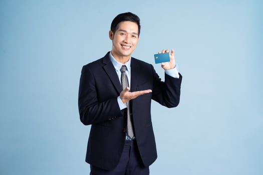 portrait of asian businessman wearing suit on blue background photo