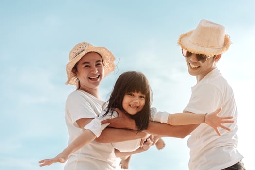Happy asian family enjoy the sea beach at consisting father, mother and daughter having fun playing beach in summer vacation on the ocean beach. Happy family with vacations time lifestyle concept. photo