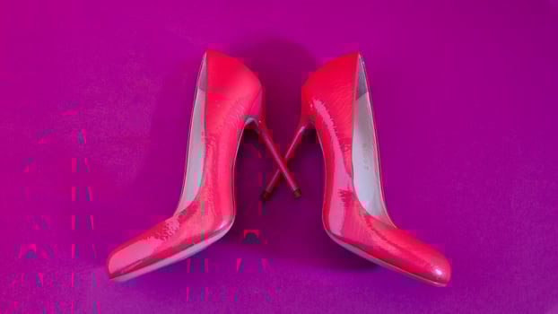 Elegant classic shoes close-up. Bright pink high heeled shoes. Pink and violet background. photo