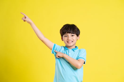 portrait of an asian boy posing on a yellow background photo