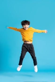 full body image of asian boy posing on blue background photo