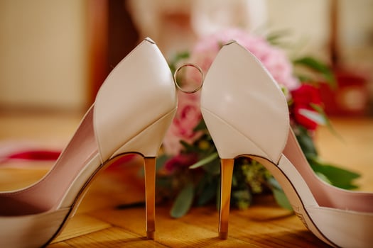 female feet in white wedding sandals with a bouquet of camomiles photo