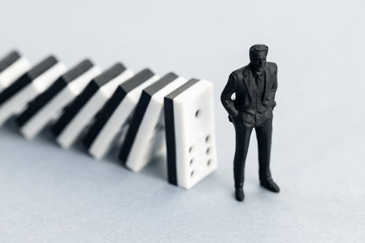 Domino effect concept. Dominoes falling and putting a company or investor at risk photo