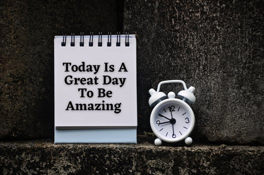 Motivational and inspirational quote on notepad - Today is a great day to be amazing. With rock and alarm clock background. photo