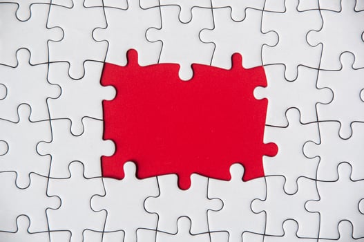 Top view of missing jigsaw puzzle on red cover background. Copy space photo