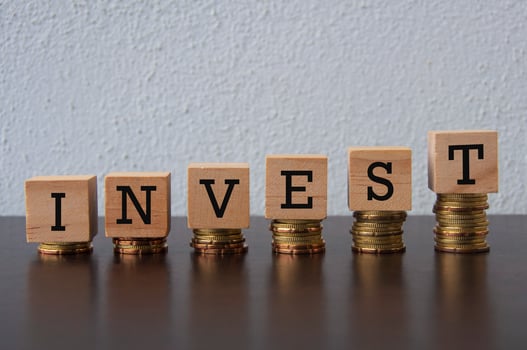 Coins Stack with Invest text on wooden blocks - Business Concept photo
