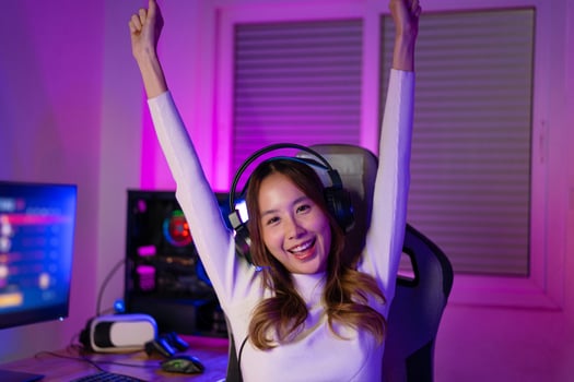 Asian gamer playing online video game winning excited on PC with lighting effect, broadcast streaming live at home. Gamer and E-Sport online gaming technology Championship tournament gamer concept. photo