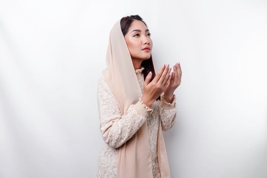 Religious beautiful Asian Muslim girl wearing a headscarf praying to God. photo