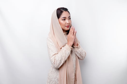 Religious beautiful Asian Muslim girl wearing a headscarf praying to God. photo