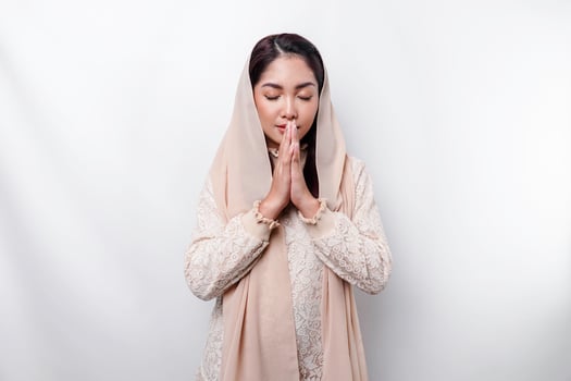 Religious beautiful Asian Muslim girl wearing a headscarf praying to God. photo