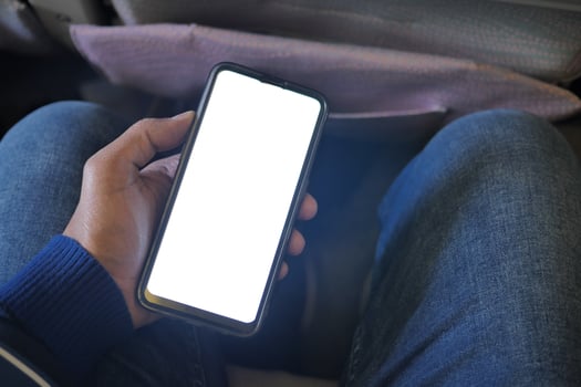 hand holding smart phone with empty screen in a car photo