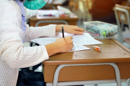 Asian school children take exams to measure and assess learning outcomes. During the epidemic situation of the corona virus by wearing a mask all the time. Soft and selective focus. photo
