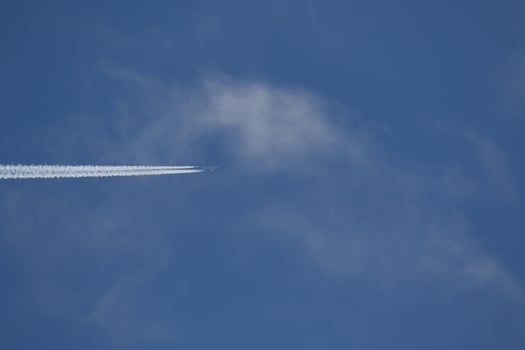 A plane and vapor trails in the sky photo