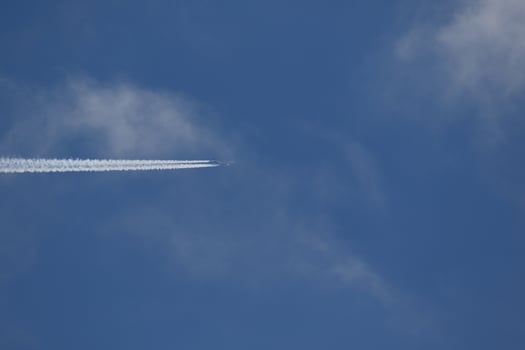 A plane and vapor trails in the sky photo