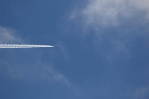A plane and vapor trails in the sky photo