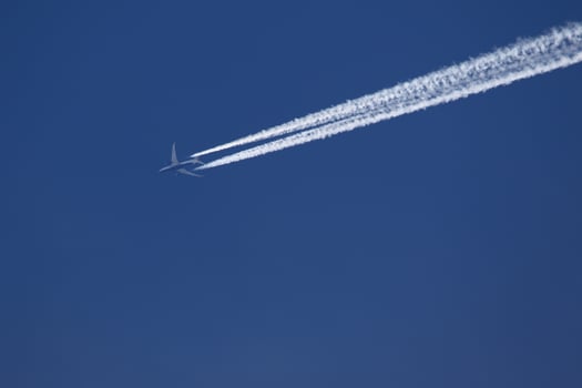 A plane and vapor trails in the sky photo
