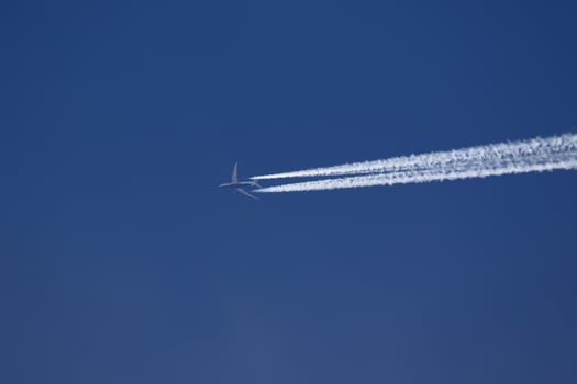 A plane and vapor trails in the sky photo