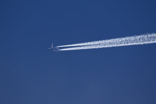 A plane and vapor trails in the sky photo