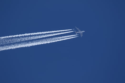 A plane and vapor trails in the sky photo