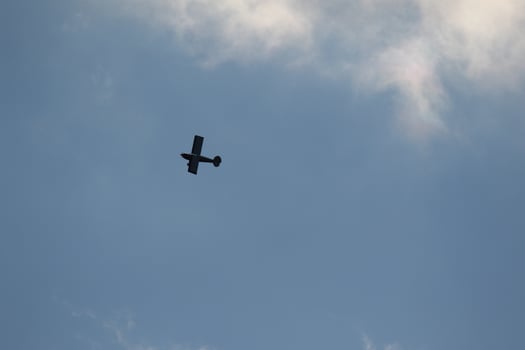 Small plane flying on a blue sky photo