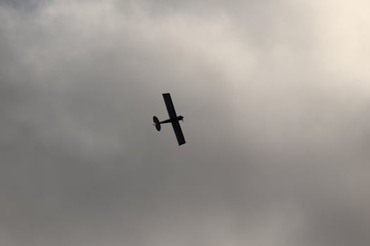 Small plane flying in the sky against dark clouds photo