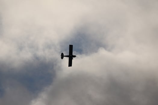 Small plane flying in the sky against dark clouds photo
